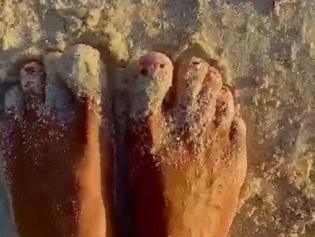 Füße die im Sand laufen