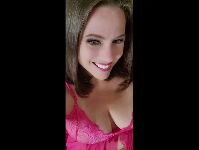 Eine sexy Milf in rosa Dessous wartet auf dem Bett auf Sie. Was wollen Sie mehr?