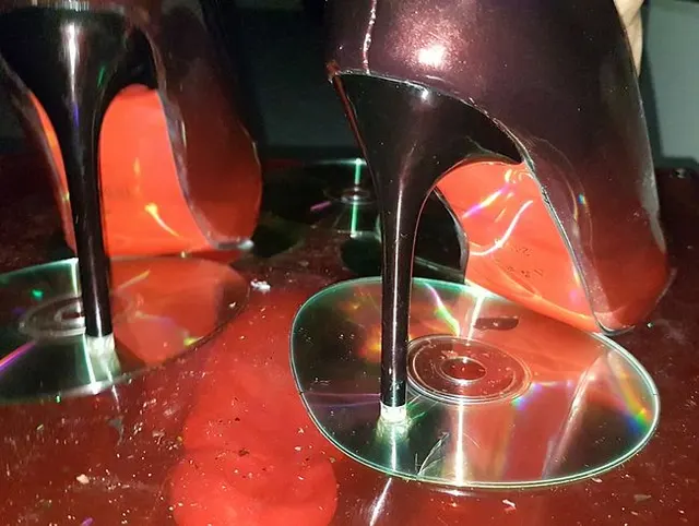schwarz-rote Lack High-Heels "tanzen" auf seinem Penis und CD`s